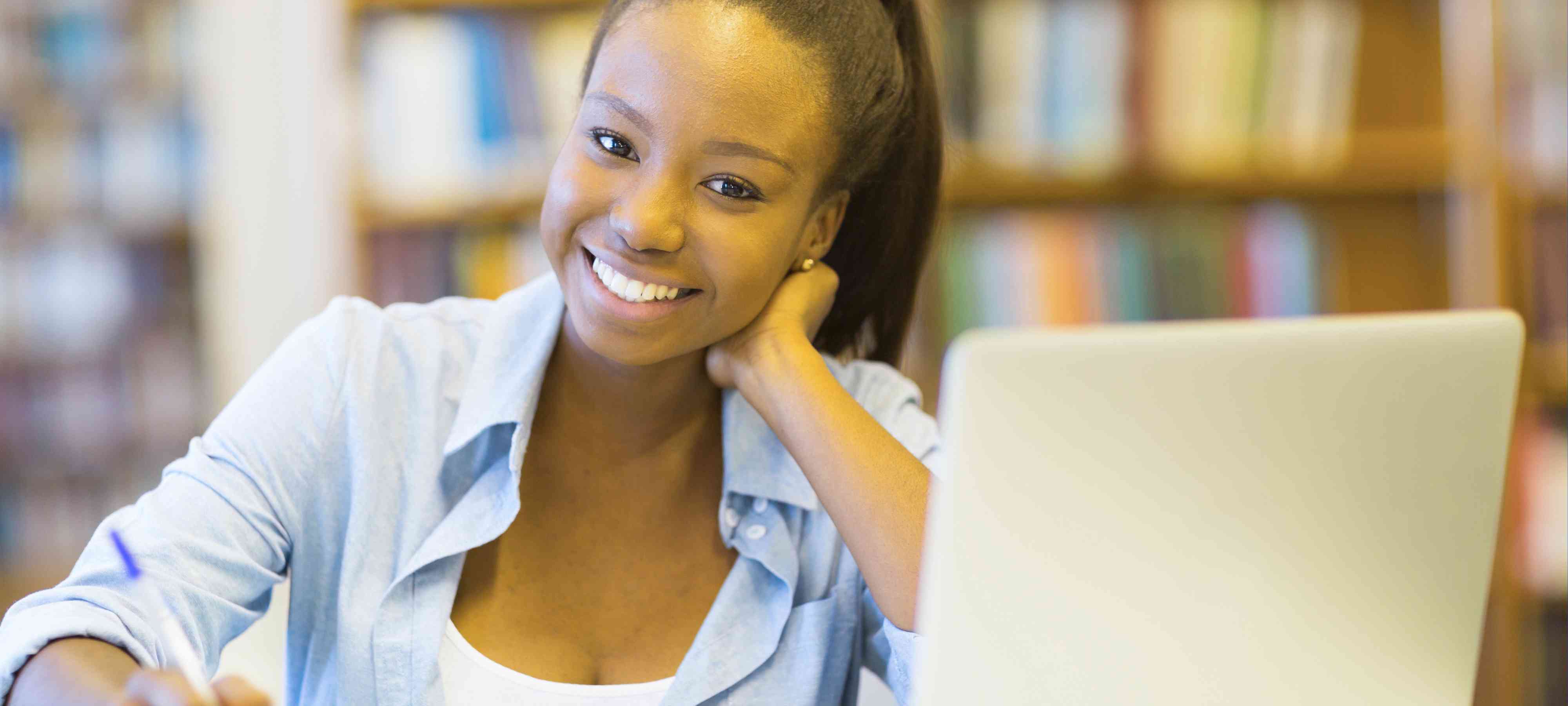 Young African-American female smiling in front of a laptop