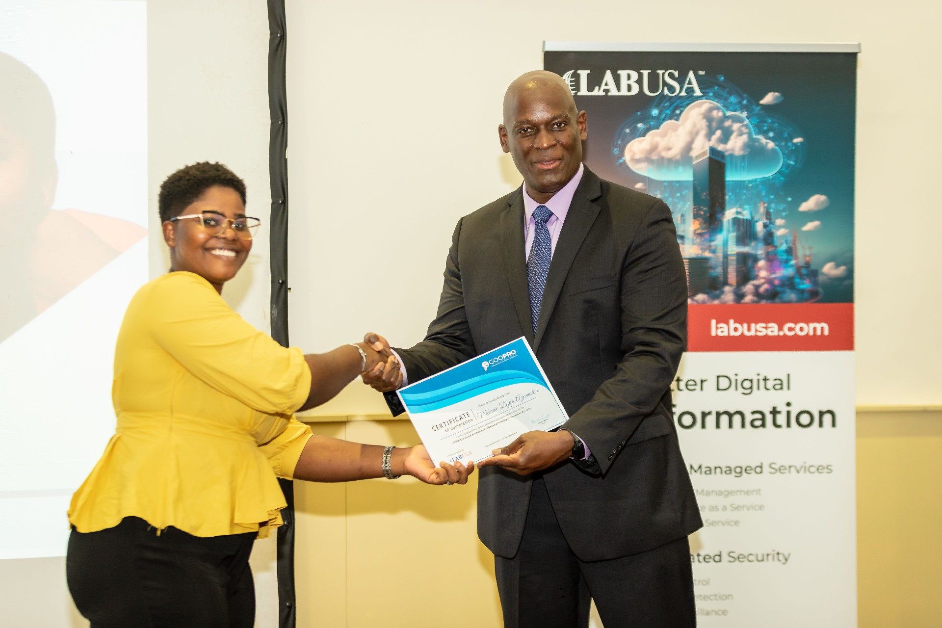 A man shaking hands with a woman while handing her a certificate