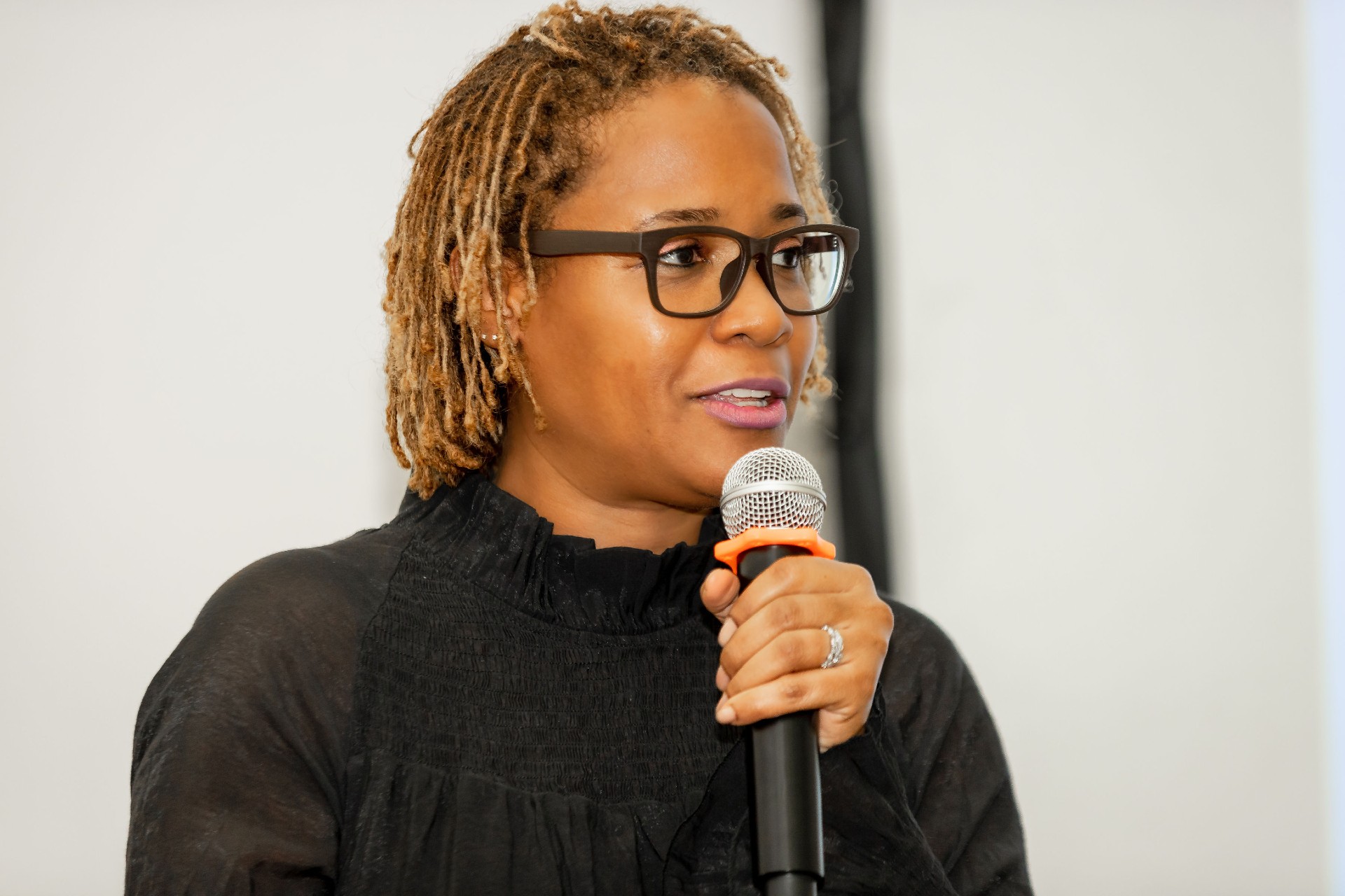 A woman holding a microphone speaking