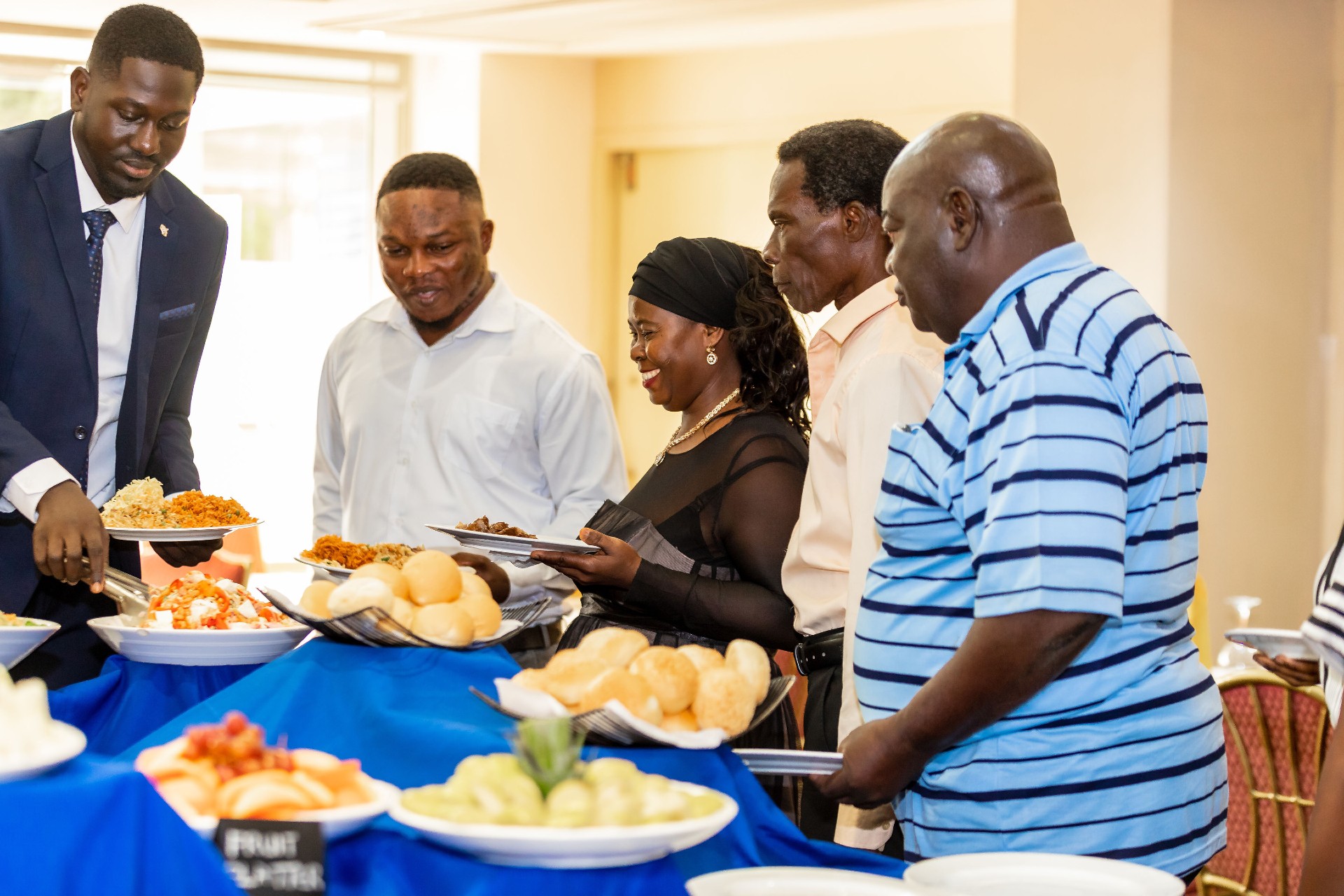 People in a buffet line serving themselves